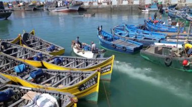 Essaouira, Fas - 17 Eylül 2022: Balıkçı Essaouira limanında bir tekneyle denize açıldı. Balıkçı tekneleri limana yanaşıyor, günün avını getiriyorlar, martılar da tepemizde daireler çiziyor.