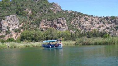 Dalyan, Türkiye - 12 Haziran 2023: Dalyan kent manzarasına oyulmuş Lycian Kaunos mezarları. Bu Kralların mezarları Dalyan nehir teknesi turu sırasında popüler bir manzara.