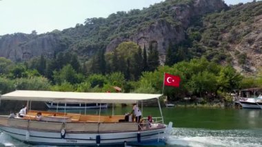 Dalyan, Türkiye - 12 Haziran 2023: Dalyan kent manzarasına oyulmuş Lycian Kaunos mezarları. Bu Kralların mezarları Dalyan nehir teknesi turu sırasında popüler bir manzara.