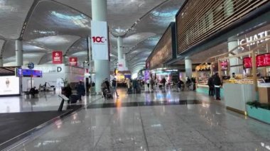 İstanbul, Türkiye - 13 Kasım 2023: İstanbul Havalimanı 'nın kalkış alanındaki yolcular, dünyanın en büyük havaalanlarından biri ve büyük bir uluslararası ulaşım merkezi olarak hizmet veriyor