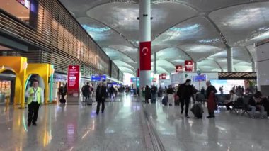 İstanbul, Türkiye - 13 Kasım 2023: İstanbul Havalimanı 'nın kalkış alanındaki yolcular, dünyanın en büyük havaalanlarından biri ve büyük bir uluslararası ulaşım merkezi olarak hizmet veriyor