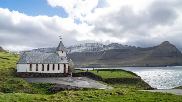 Vidareidi köyü kilisesi çevreyi saran tepeler ve Kuzey Atlantik Okyanusu, Faroe Adaları, Danimarka.