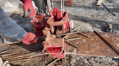 İstanbul, Türkiye - 12 Ocak 2024: Armatür bükme makinesinde çalışan bir işçinin elleri. İnşaat demiri bükme makinesiyle inşaat demirleri.