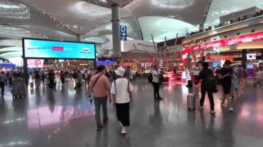İstanbul, Türkiye - 5 Haziran 2024: İstanbul Havalimanı 'nın kalkış alanındaki yolcular, büyük bir uluslararası ulaşım merkezi olarak hizmet veren dünyanın en büyük havaalanlarından biri.