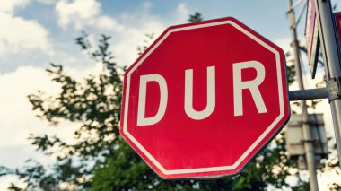 Yol işareti DUR Türkçe. Uluslararası trafik levhası olarak çevrilebilir..