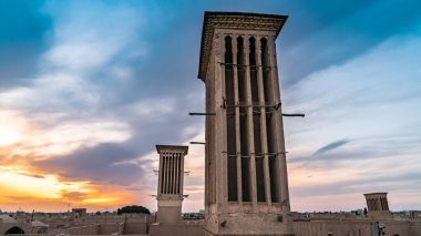 Bir badgir, İran Yazd şehrinde günbatımında rüzgar yakalayan kule. Badgirl 'ler havalı binalara alışıktır. Evlere esinti pompalarlar, doğal havalandırma sağlarlar..
