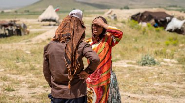Şiraz, İran - 5 Mayıs 2019: Kashqai Türk erkek ve kadın konuşması. Qashqai geçici köylerde yaşayan göçebe insanlardır. Qashqai göçebe kampı