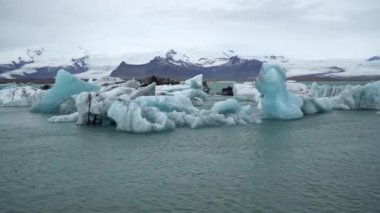 Jokulsarlon buzulu gölünde yüzen buzdağları eriyen buz ve iklim değişikliğinin küresel ısınmaya ve İzlanda 'ya neden olan etkilerini gözler önüne seriyor.