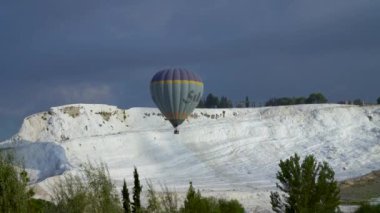 Denizli, Türkiye - 24 Şubat 2020: Pamukkale travertininde uçan sıcak hava balonları. Pamukkale üzerinde bir balona binmek çok popüler bir turistik etkinliktir.