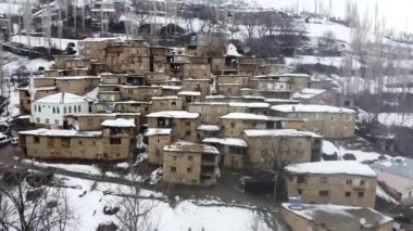 Hizan, Bitlis, Türkiye 'de uzak bir köyde karla kaplı taş evler, kışın Anadolu manzarasını gözler önüne seriyor.