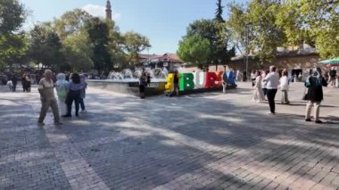 Bursa, Türkiye - 24 Ağustos 2024: İnsanlar şehrin merkezindeki Bursa tabelasında yürüyorlar. Bursa, Türkiye 'de çok popüler bir şehirdir..