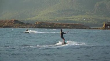 Marmaris, Akyaka, Türkiye - 30 Eylül 2024: Uçurtmacılar için bir numaralı durak olan Akyaka Sahili 'nde uçurtma uçuran adam, güçlü kıyı rüzgarları ile uçurtma sörfü için ideal koşullar yaratıyor