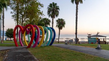 Kemer, Antalya, Türkiye - 5 Ekim 2024: Türkiye 'nin Kemer kentinde, gözde bir Akdeniz turizm merkezi olan canlı kalp şekilli çerçeveler, fotoğraflar için mükemmel. Ziyaretçiler renkli manzaraları yakalamak için akın ediyorlar.