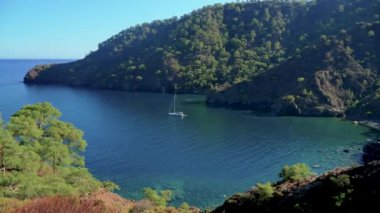 Antalya 'nın çarpıcı Türk Akdeniz kıyılarında, yemyeşil ormanlarla çevrili mavi bir denizin içinde ve engebeli kayalık kıyılarda her yaz turistleri çeken bir yat..