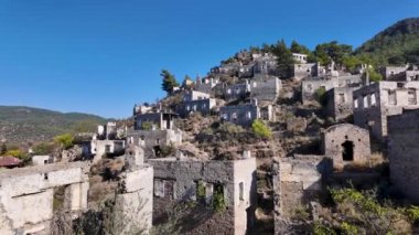 Fethiye yakınlarındaki Kayakoy hayalet kasabası, Mugla, Türkiye. Yıkık dökük taş evleri, tarihi kalıntıları ve akıllara durgunluk veren bir dağ manzarası olan terk edilmiş bir Yunan köyü..
