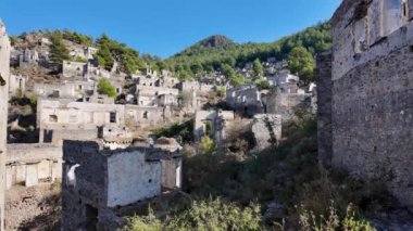 Fethiye yakınlarındaki Kayakoy hayalet kasabası, Mugla, Türkiye. Yıkık dökük taş evleri, tarihi kalıntıları ve akıllara durgunluk veren bir dağ manzarası olan terk edilmiş bir Yunan köyü..