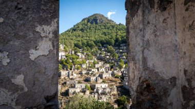 Fethiye yakınlarındaki Kayakoy hayalet kasabası, Mugla, Türkiye. Yıkık dökük taş evleri, tarihi kalıntıları ve akıllara durgunluk veren bir dağ manzarası olan terk edilmiş bir Yunan köyü..