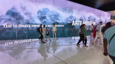 Dubai, BAE - 13 Kasım 2024: Dubai AVM 'nin devasa kapalı alan LED ekranı okyanus temalı görseller sergiliyor, canlı alışveriş alanında gezinirken büyüleyici ziyaretçiler.