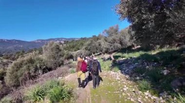 Dalyan, Türkiye - 7 Aralık 2024: Yeşillik ormanlarla çevrili Akdeniz kıyıları boyunca yürüyüş yapan yürüyüşçüler