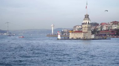 İstanbul, Türkiye - 19 Mart 2019: Bakireler Kulesi İstanbul şehrinin ufuk çizgisi ve tepesinde bir feribot geçidi bulunan İstanbul Boğazı üzerinde bulunuyor. Yavaş çekim videosu