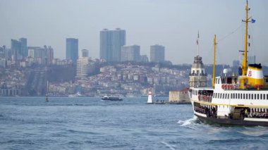 İstanbul, Türkiye - 19 Mart 2019: Bakireler Kulesi İstanbul şehrinin ufuk çizgisi ve tepesinde bir feribot geçidi bulunan İstanbul Boğazı üzerinde bulunuyor. Yavaş çekim videosu