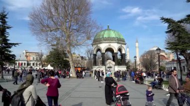 İstanbul, Türkiye - 12 Mart 2019: Sultanahmet Meydanı 'ndaki tarihi Alman Çeşmesi' nde turist kalabalığı, ikonik kubbe ve Osmanlı mimarisi görülüyor. Yavaş çekim videosu