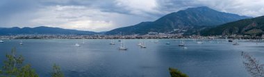 Fethiye ilçesinin panoramik manzarası. Canlı liman, tekne ve yatlarla dolu. Manzaralı bir sahil kasabasına karşı kurulmuş ve gün ışığında Akdeniz suları sakin..