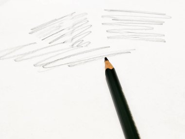 Kağıttaki çiziğin üstündeki bir kalem resmi. 