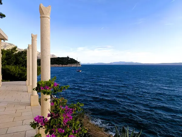 Adriyatik Denizi 'nde Bougainvillea çiçekleri ve bir yelkenli, Makarska, Hırvatistan