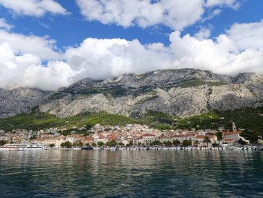 Makarska, Biokovo dağı ve limandaki Adriyatik denizi üzerinde bulutlu bir gün