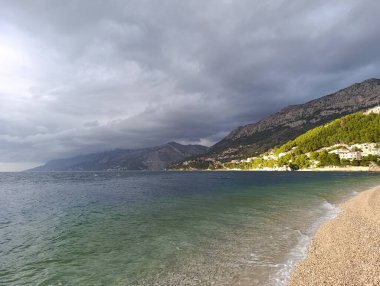 Kışın boş kumsalda kara fırtınalı bir gökyüzü.