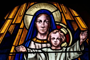 Pegomas, FRANCE - 03-05-2025: Kutsanmış Bakire Meryem 'in meleklerle çevrelenmiş cennetteki varlığının lekeli camı (20. yüzyılın başlarında)