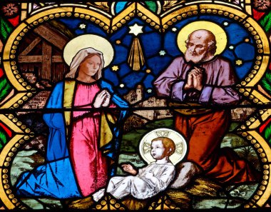 Joigny, FRANCE - 01-28-2025: Bakire Meryem, Aziz Joseph ve İsa 'nın bebeğiyle Noel İsa' nın doğum sahnesinin lekeli camları (19. yüzyıl).
