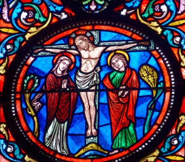 Dijon, FRANCE - 01-30-2025: Çarmıha gerilen İsa Mesih 'in lekeli camları (19. yüzyıl) Marie ve Aziz John ile temsil ediliyor..