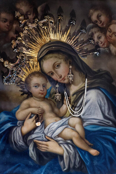 Naples, ITALY - 10-24-2024: Painting (19th century) of Blessed Virgin Mary holding baby Jesus Christ in her arms.