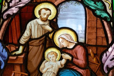 Paris, FRANCE - 10-14-2024: Kutsal ailenin lekeli camları (19. yüzyıl): Marangoz Yusuf 'un atölyesinde İsa' nın bebeği, Bakire Meryem ve Aziz Joseph. 