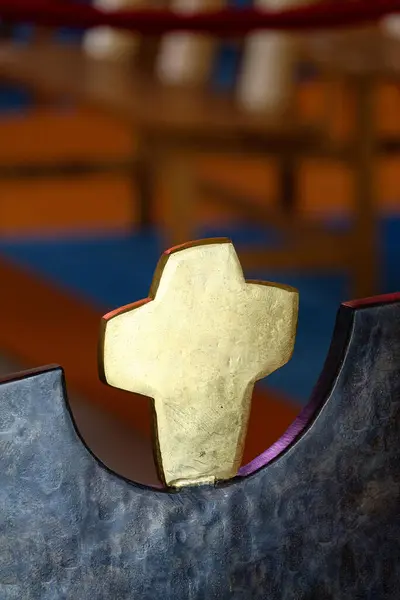 La Grande Motte, FRANCE - 08-10-2024: Arka ışıklandırması olan bir kilisede modern bronz haç