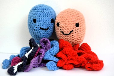 Mavi - mor ve pembe - kırmızı amigurumi ahtapot, bebekler için iyidir, dalgalı kollar bebeğe göbek bağını hatırlatır.