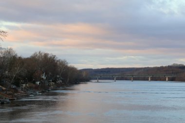 Parkta ağaçlarla çevrili bir nehrin dikey görüntüsü.