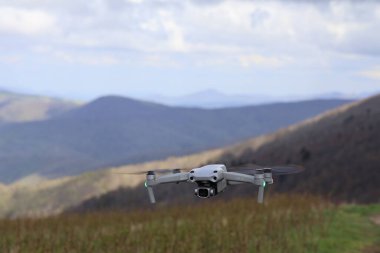 Dağların üzerinden uçan gri İHA 'nın hava görüntüsü