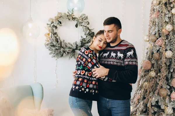 在家里 一对穿着传统毛衣装饰圣诞树的快乐夫妇在一起 — 图库照片