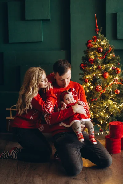 幸せな家族のお母さんお父さんと小さな娘で赤伝統的なクリスマス服一緒に過ごす時間近くクリスマスツリー コピースペース — ストック写真