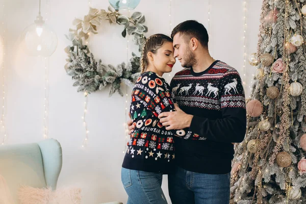 在家里 一对穿着传统毛衣装饰圣诞树的快乐夫妇在一起 — 图库照片