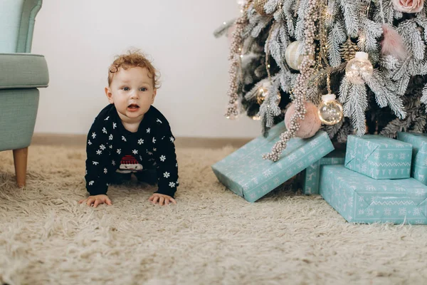 전통적 크리스마스 스웨터를 곱슬머리의 아이가 크리스마스 집에서 시간을 보낸다 — 스톡 사진