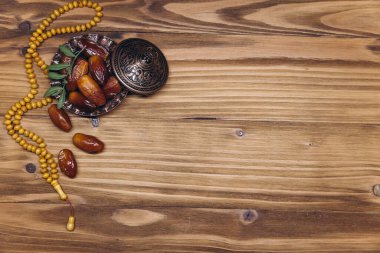 Dekorasyonun masa üstü görüntüsü Ramazan Kareem, ahşap zemin üzerinde meyve ve tespih taşları. Kopyalama alanı olan düz.