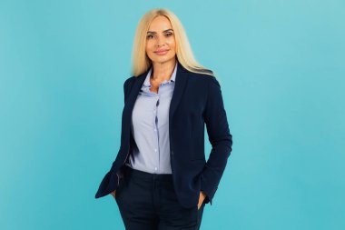 Mavi arka planda orta yaşlı çekici bir iş kadınının portresi.
