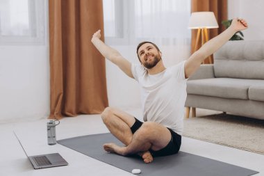 Karantinada sakin olun. Millennial elemanı antrenörle internetten laptopla meditasyon yapıyor. Boş alan.