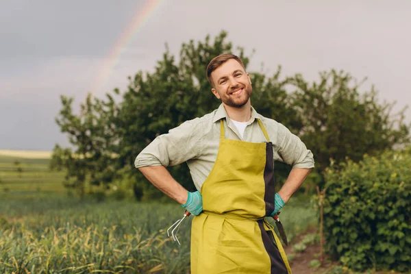 一个男农场主在花园彩虹背景上微笑的画像 — 图库照片