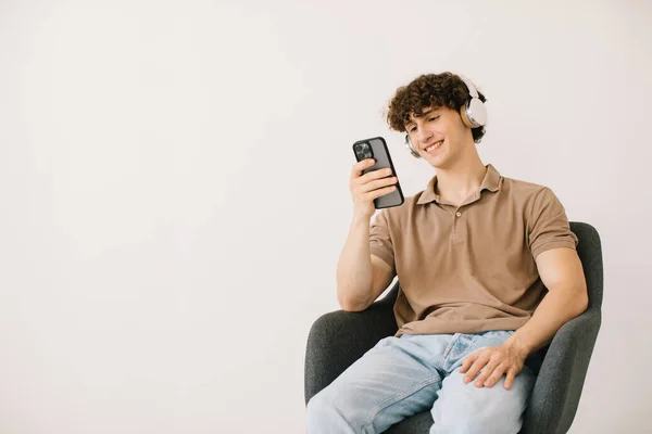 Aantrekkelijke Jongeman Die Laptop Gebruikt Koptelefoon Draagt Terwijl Hij Een — Stockfoto