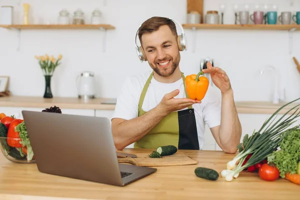 Homem Feliz Fones Ouvido Sentado Mesa Cozinha Preparando Salada Segurando — Fotografia de Stock